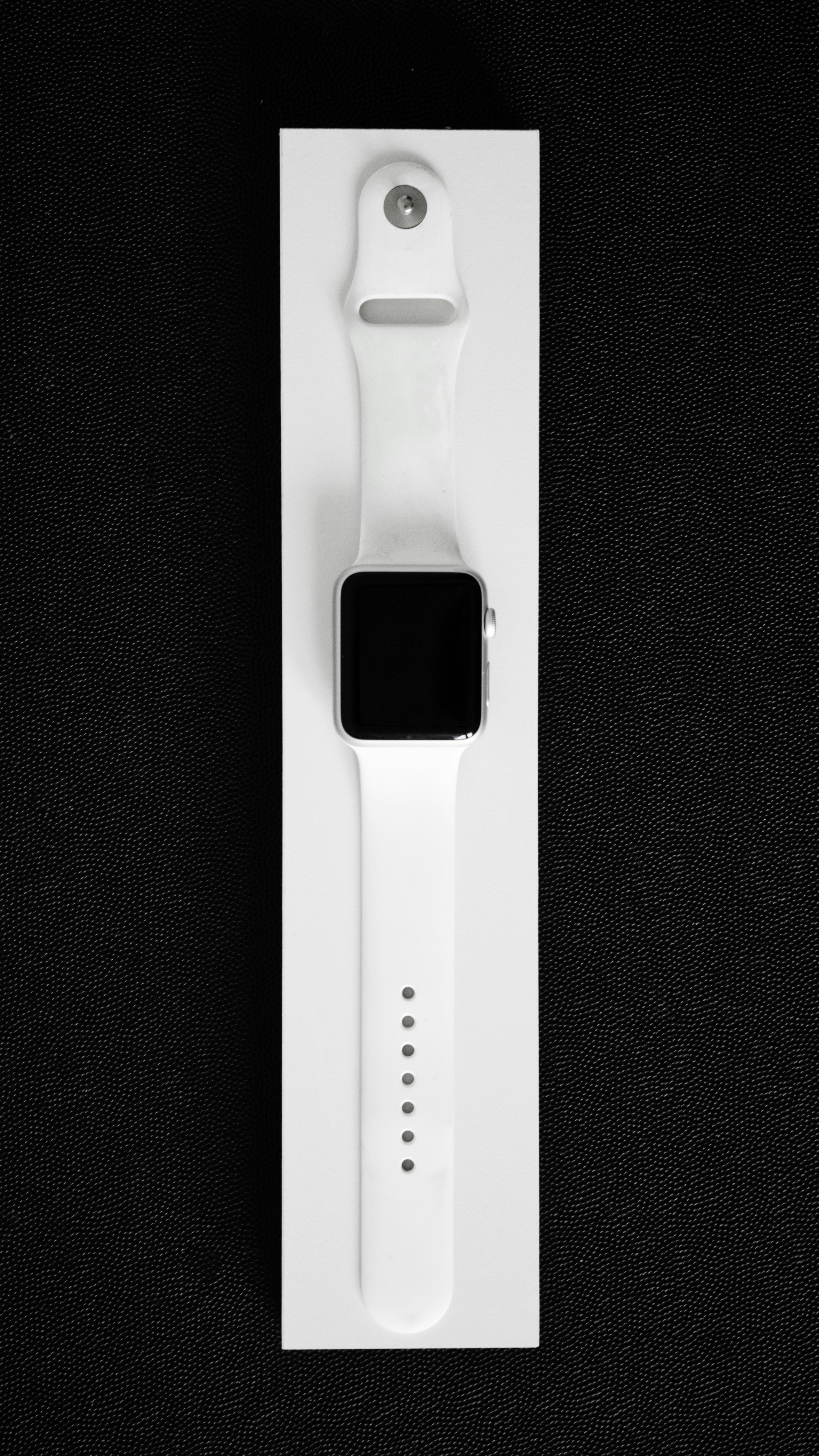 Apple smartwatch with a white band in its box.
